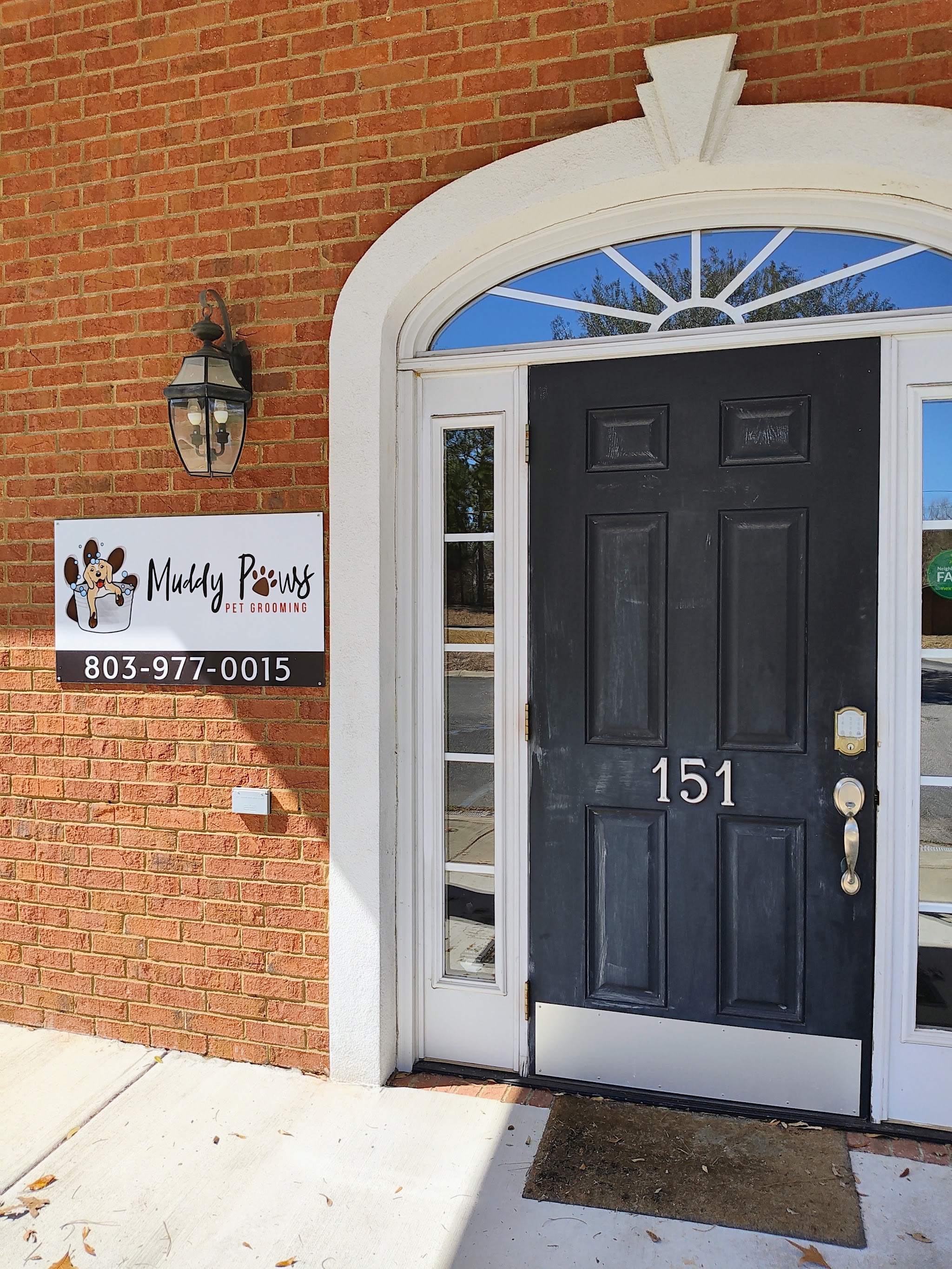 Front door of our brick building with the Muddy Paws sign